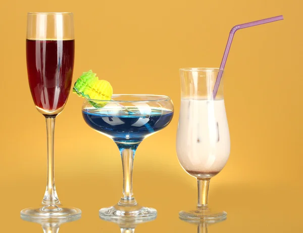 A variety of alcoholic drinks on yellow background — Stock Photo, Image