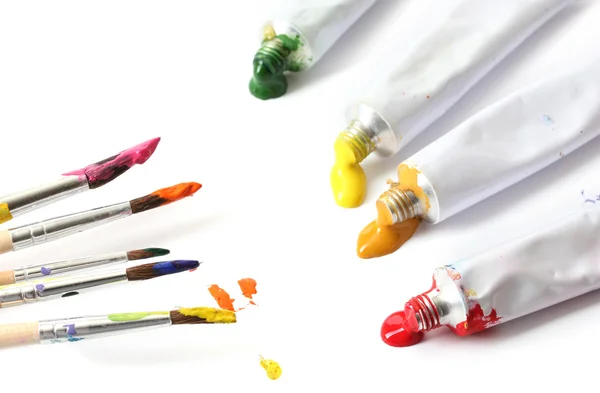 Soyut akrilik boya, boya tüpleri ve üzerinde beyaz izole fırçalar — Stok fotoğraf