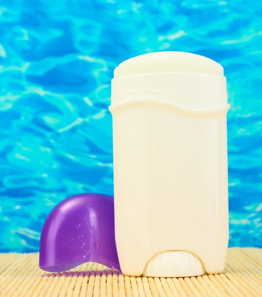 Desodorante sobre fondo marino azul — Foto de Stock