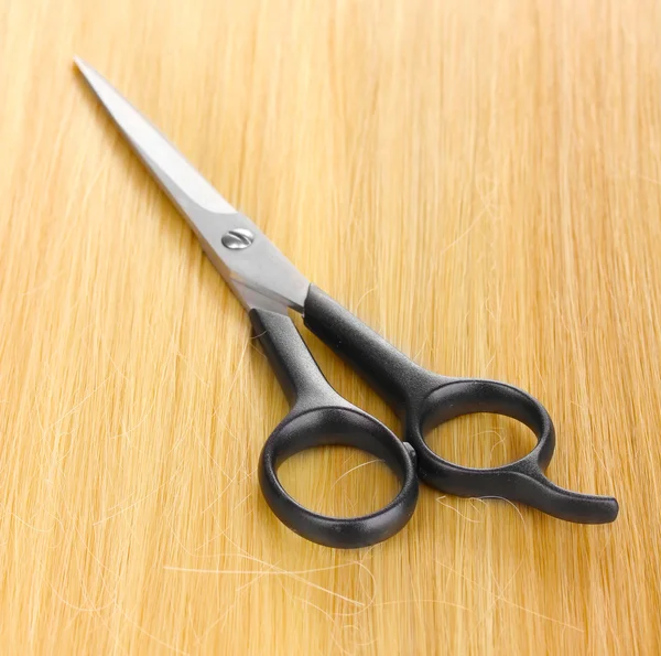 Glanzende blond haar en haar snijden schaar close-up — Stockfoto