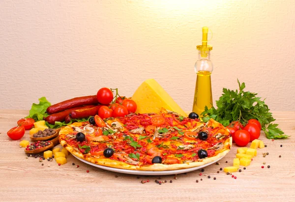 stock image Delicious pizza, vegetables and salami on wooden table