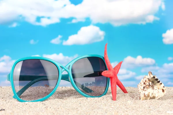 Elegante Sonnenbrille für Frauen mit Seesternen und Muscheln am Strand — Stockfoto