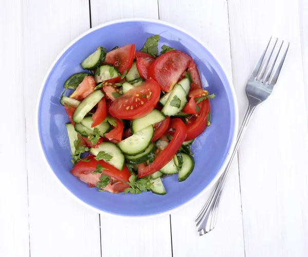 Свіжий салат з помідорами та огірками на білому дерев'яному фоні — стокове фото