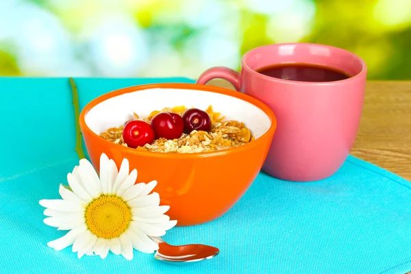 Tasty cereal with cherries for breakfast on wooden table on green background — Stock Photo, Image