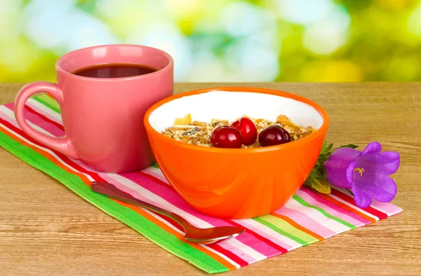 Sabroso cereal con cerezas para el desayuno en mesa de madera sobre fondo verde — Foto de Stock