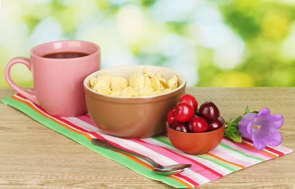 Cereais saborosos com cerejas para o café da manhã na mesa de madeira no fundo verde — Fotografia de Stock