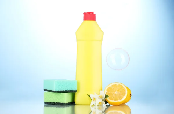 Sünger ve çiçekli mavi zemin üzerine limon ile bulaşık deterjanı — Stok fotoğraf