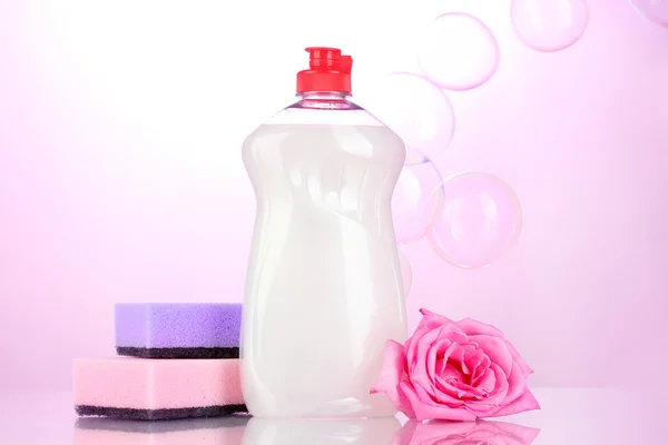 스폰지와 분홍색 배경에 꽃 주방용 액체 — 스톡 사진