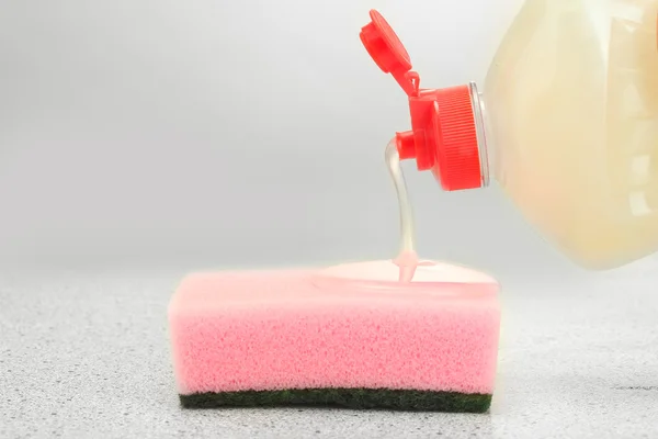 Esponja brilhante com líquido de lavagem de prato no fundo de mármore — Fotografia de Stock