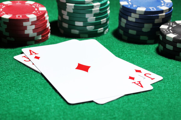 Cards and chips for poker on green table