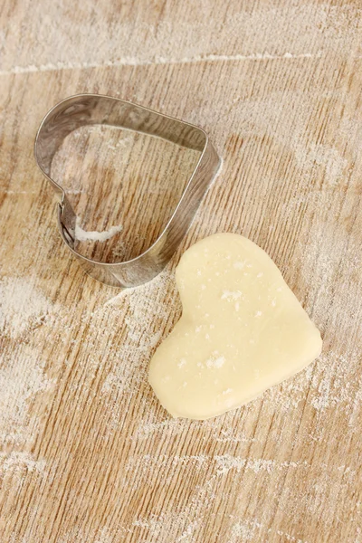 Řezačka pro těsta nepečený sušenky na dřevěný stůl detail — Stock fotografie