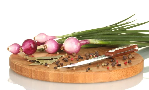 Cebolla joven con pimienta en una tabla de cortar aislada en blanco —  Fotos de Stock