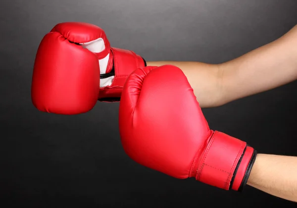 Red boxing gloves on hands on grey background — Stock Photo, Image