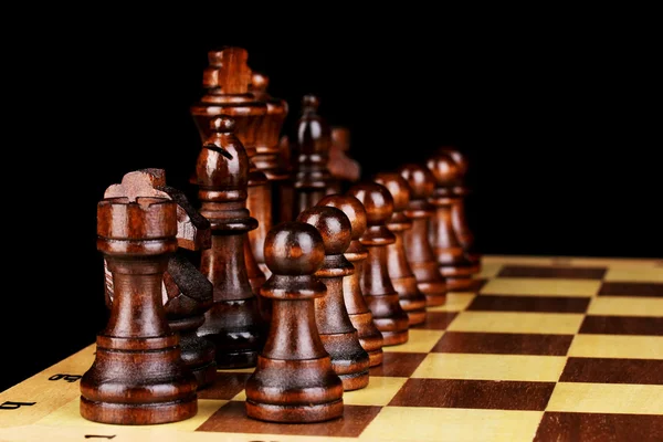 Schachbrett mit Schachfiguren isoliert auf schwarz — Stockfoto
