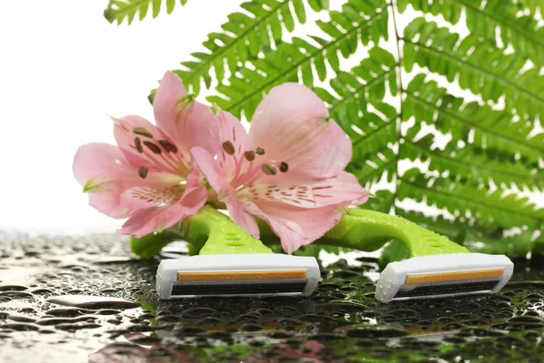 Woman safety shavers with drops, leaf and flowers on grey backgroud