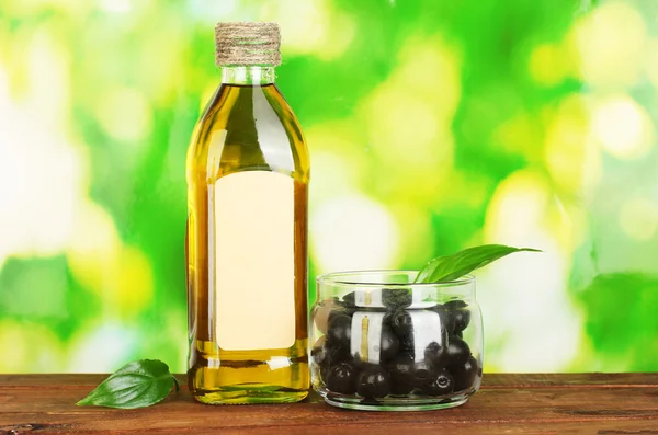 Olive oil bottle on green background — Stock Photo, Image