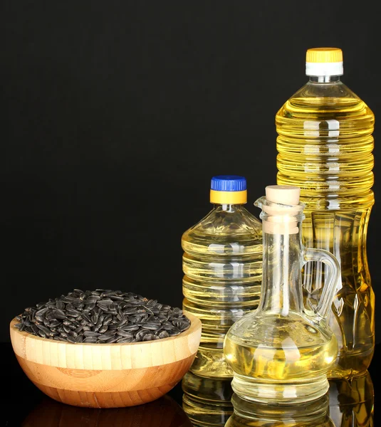Olej słonecznikowy w butelkach na białym tle na czarnym tle — Zdjęcie stockowe