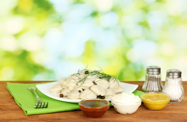 Delicious cooked dumplings in the dish on bright green background — Stock Photo, Image