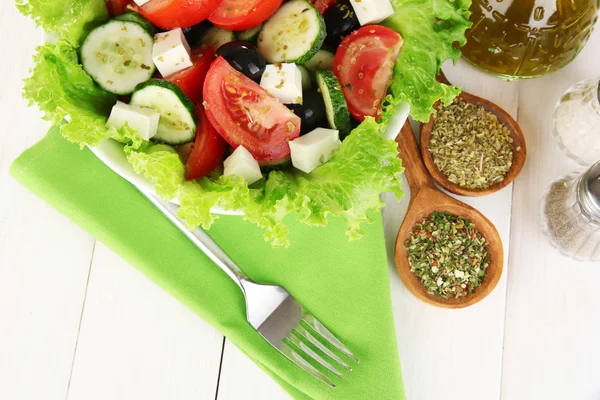 Saborosa salada grega com especiarias em fundo de madeira branca close-up — Fotografia de Stock