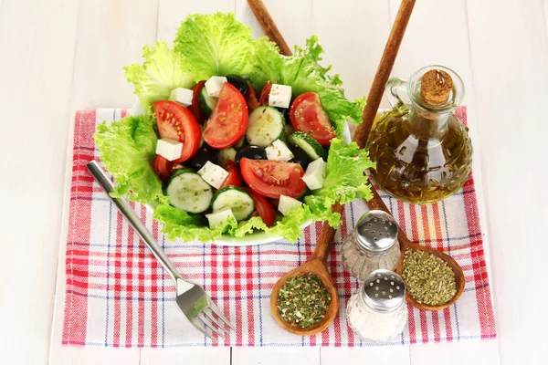 Вкусный греческий салат со специями на белом деревянном фоне крупным планом — стоковое фото