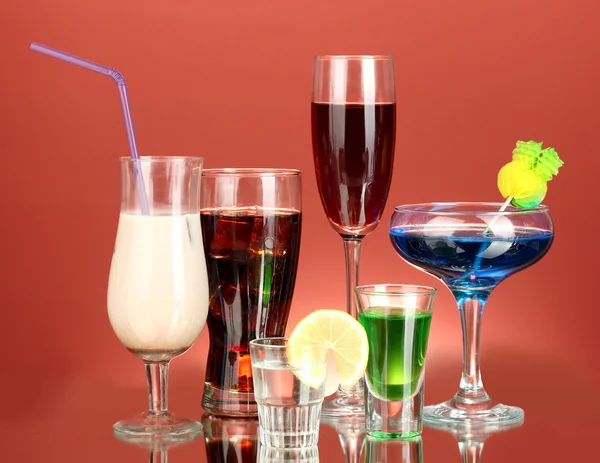 Una varietà di bevande alcoliche su sfondo rosso — Foto Stock