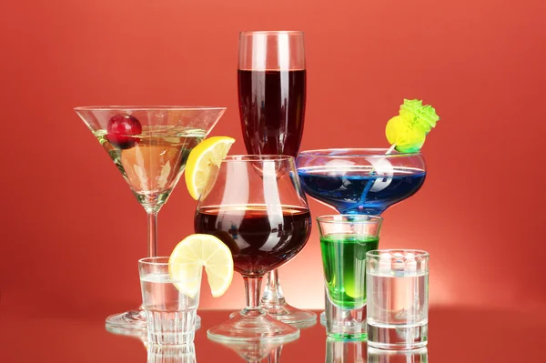 Een scala aan alcoholische dranken op rode achtergrond — Stockfoto