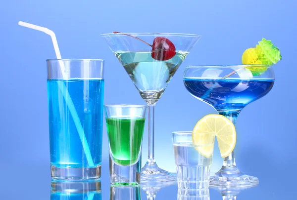 Una variedad de bebidas alcohólicas sobre fondo azul — Foto de Stock