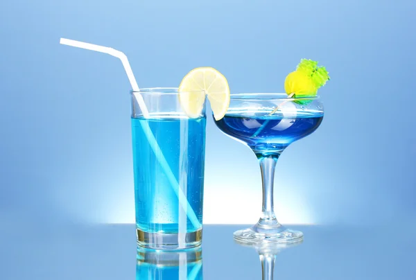 Различные алкогольные напитки на синем фоне — стоковое фото