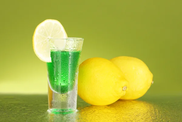 Stack of absinthe on green background — Stock Photo, Image