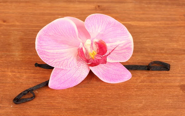 Vainas de vainilla con flor sobre fondo de madera —  Fotos de Stock