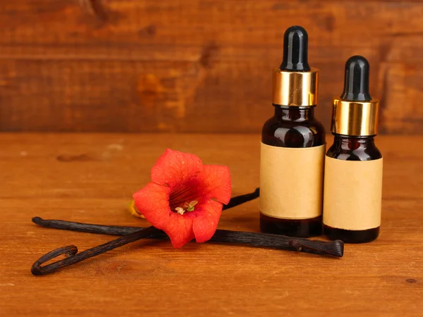 Vanilkové lusky s esenciální olej na dřevěné pozadí detail — Stock fotografie