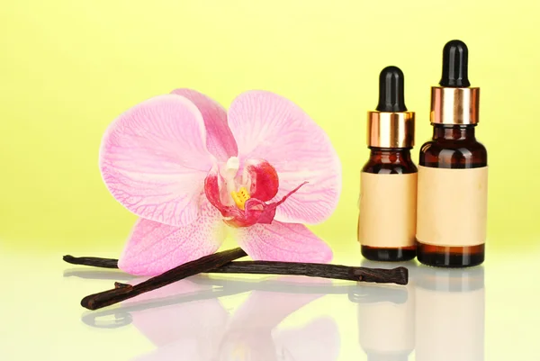 Vanilkové lusky s esenciálním olejem na barevné pozadí — Stock fotografie