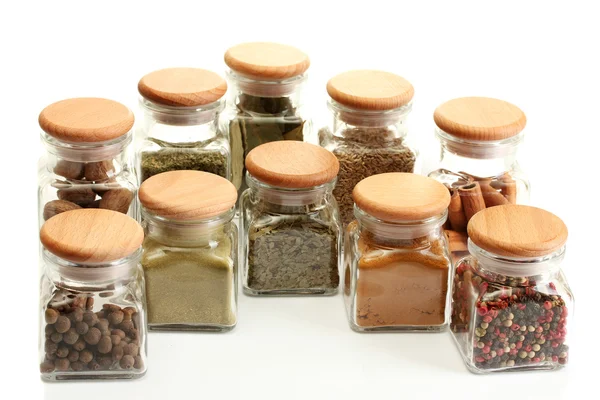 Especiarias em pó em frascos de vidro isolados em branco — Fotografia de Stock
