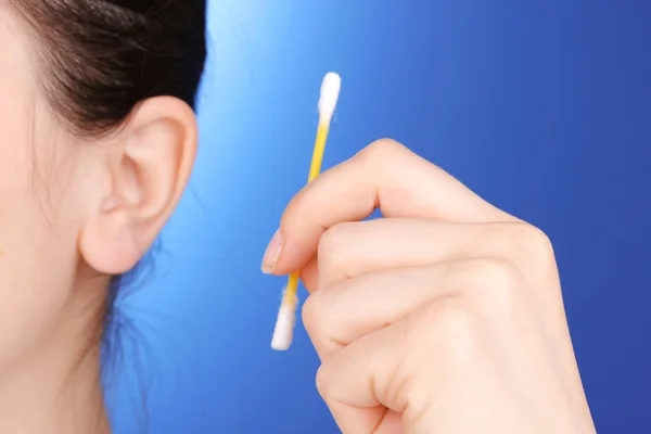 Tamponi di cotone e orecchio umano primo piano su sfondo blu — Foto Stock