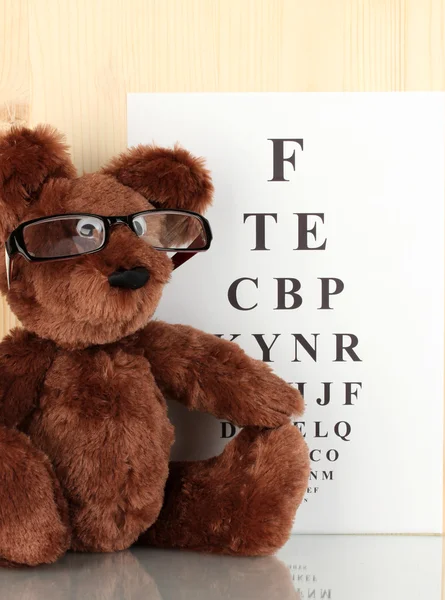 stock image Teddy bear with glasses on eyesight test chart background close-up