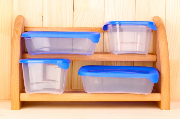 Kunststoffbehälter für Lebensmittel im Regal auf Holzgrund — Stockfoto