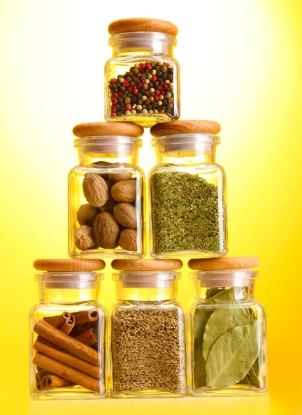 Por fűszerek, a sárga háttér üvegedények — Stock Fotó