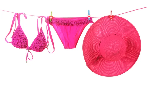 stock image Women's swimsuit and hat hanging on a rope on white background