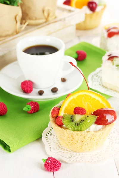 杯咖啡和甜蛋糕用木桌子上的水果 — 图库照片