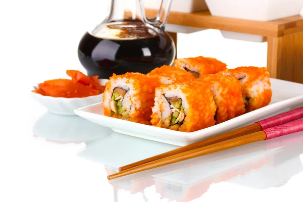 Delicioso sushi no prato, pauzinhos, molho de soja, peixe e camarões isolados em branco — Fotografia de Stock