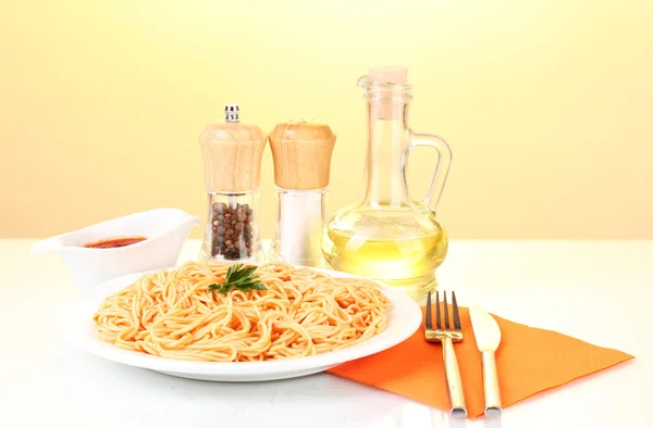 Composición de deliciosos espaguetis cocidos con salsa de tomate sobre fondo colorido brillante — Foto de Stock