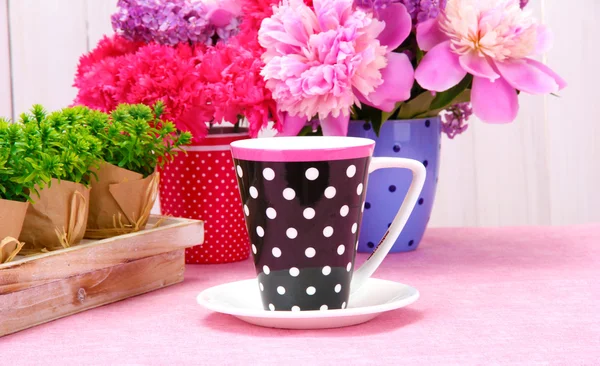 春天的花朵和木在白色背景上桌上的杯子 — 图库照片