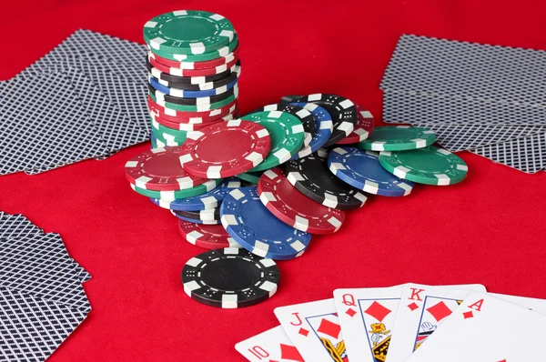 Королевский флеш с фишками для покера на красном покерном столе крупным планом — стоковое фото