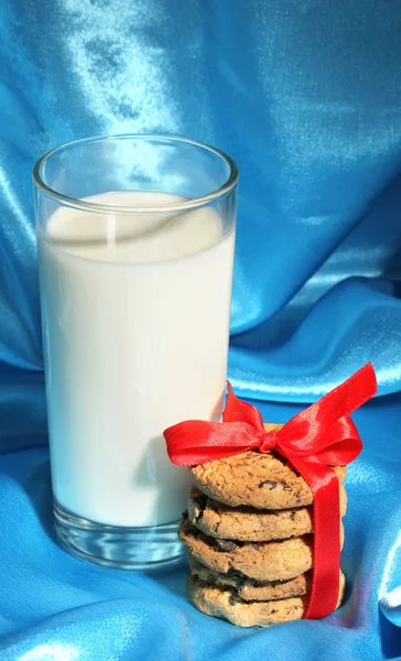 Bicchiere di latte e biscotti su sfondo di stoffa blu — Foto Stock