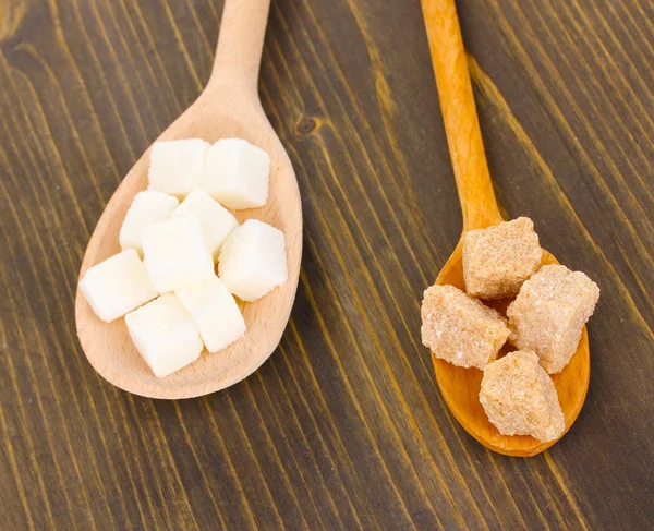 Άσπρων και καφετιών ζάχαρης σε κουτάλια σε ξύλινα φόντο — Φωτογραφία Αρχείου