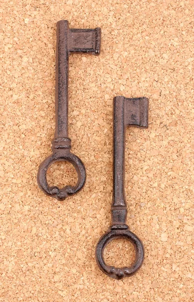 Dwie zabytkowe klucze na tle korka — Zdjęcie stockowe