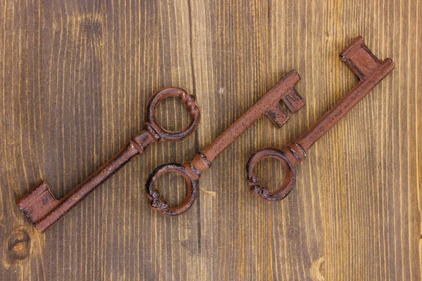 Kolme antiikki avaimet puinen tausta — kuvapankkivalokuva