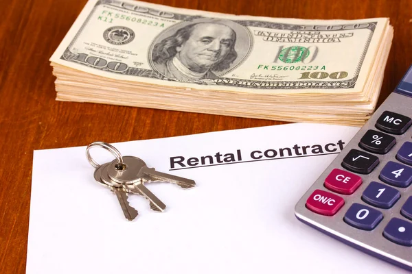 Rental contract with dollars on wooden background close-up — Stock Photo, Image