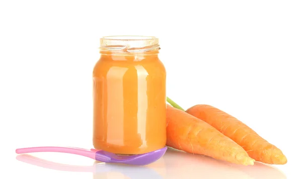Glas mit Karotte Babynahrung und Löffel isoliert auf weiß — Stockfoto