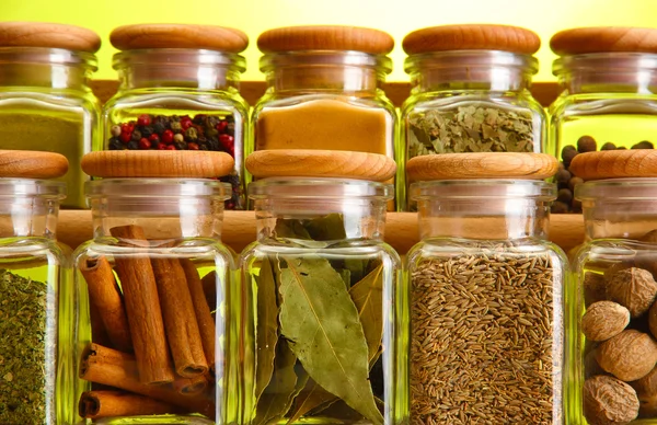 Poeder specerijen in glazen potten op groene achtergrond — Stockfoto